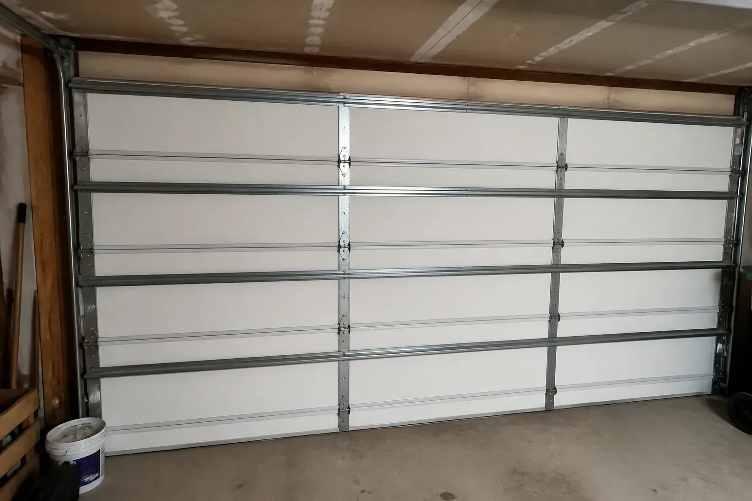 Interior of a closed sectional door with horizontal metal reinforcement struts. — Wind-Rated Garage Door Replacement, Wilmot